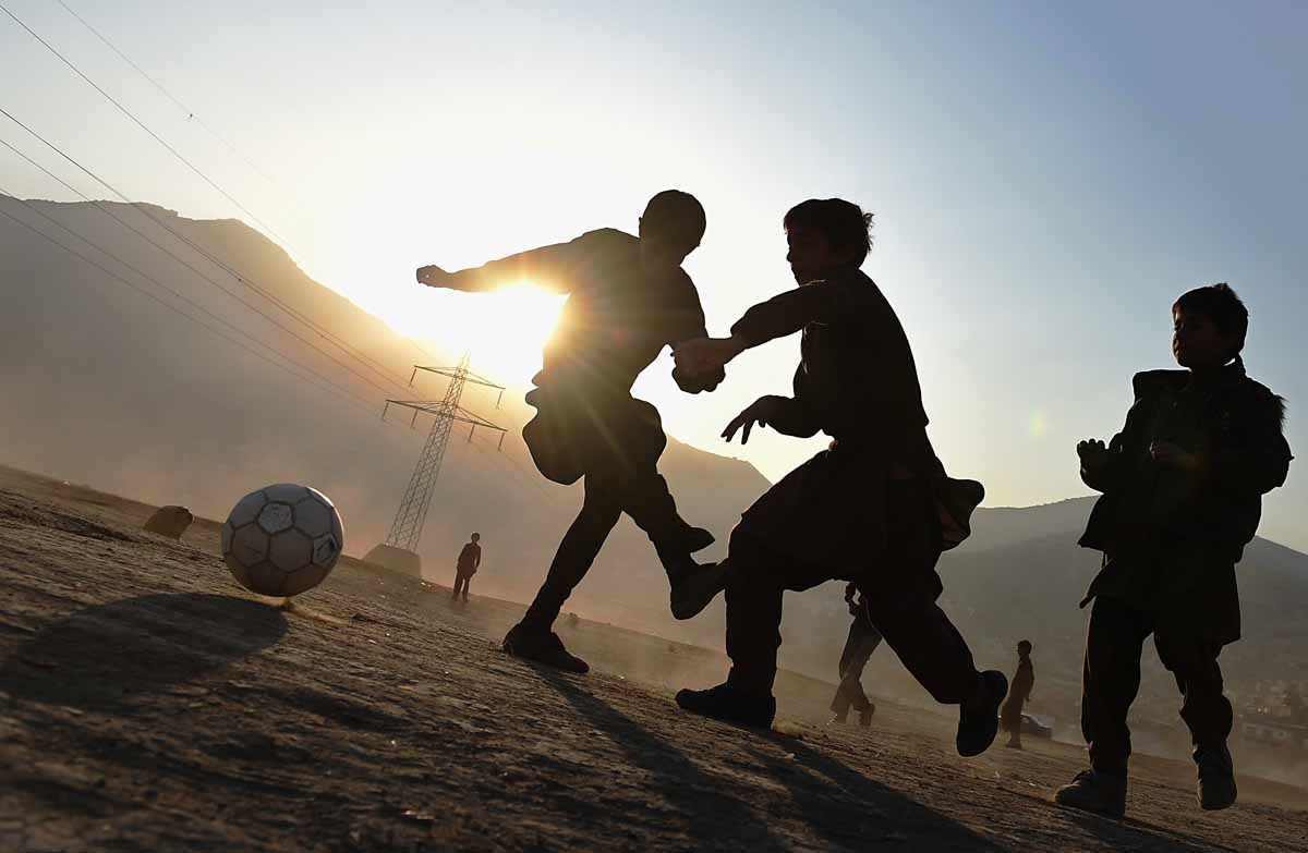 Afghan children play football in a field in Kabul on November 23, 2014. Football is one of the most popular games in Afghanistan and is played on dusty dry ground more often than grass. AFP PHOTO/SHAH Marai / AFP PHOTO / SHAH MARAI