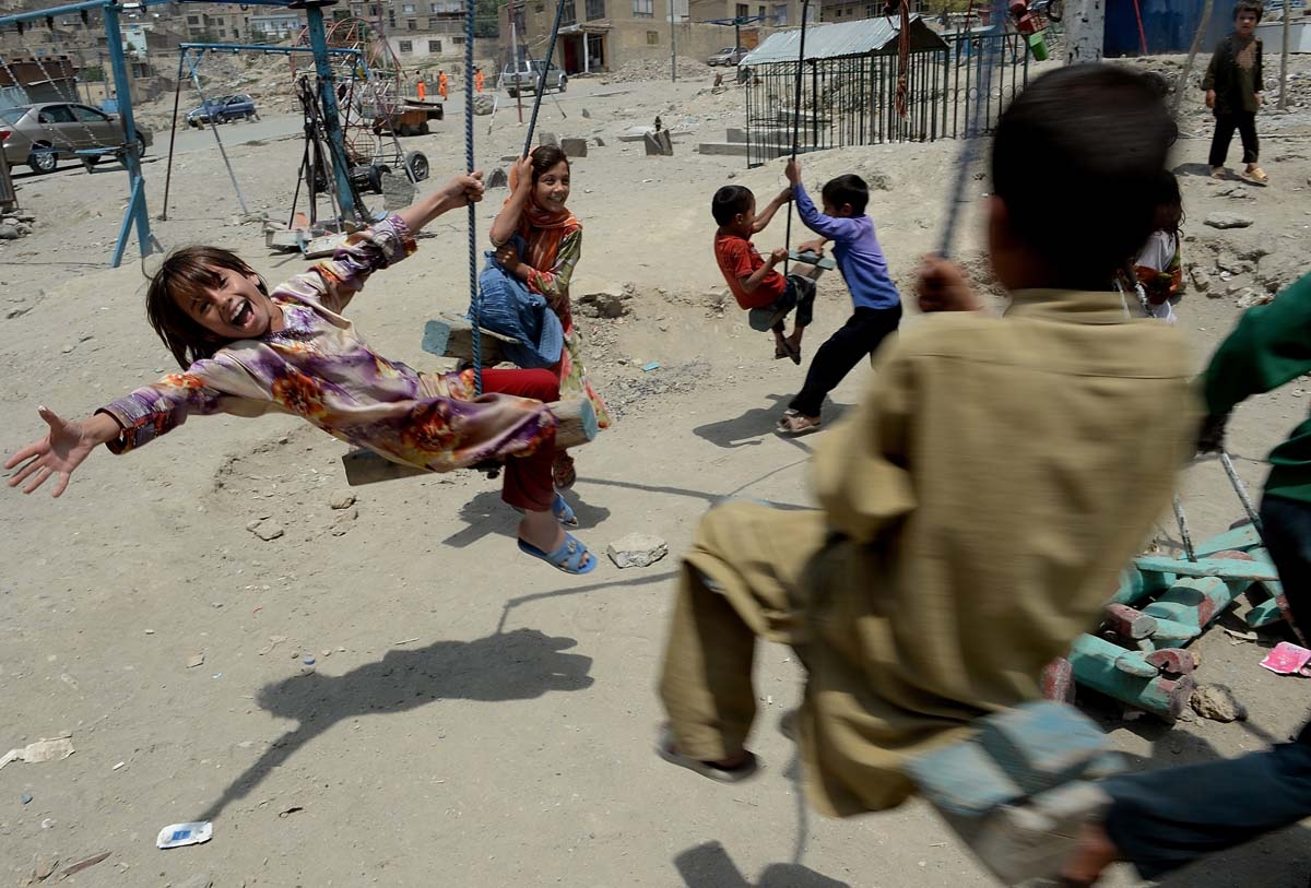Niños afganos juegan en columpios en Kabul, en 2013 (AFP / Shah Marai)