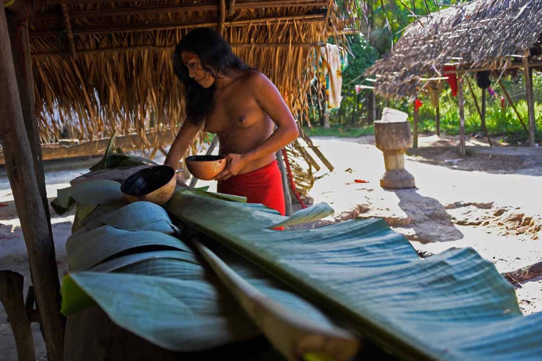 A Waiapi woman prepares Caxiri, a craft beer made with Manioc, imbibed daily by men, women and children when is not yet sour yet, at the indigenous reserve Waiapi on the Manilha village in Amapa state in Brazil on October 12, 2017.
