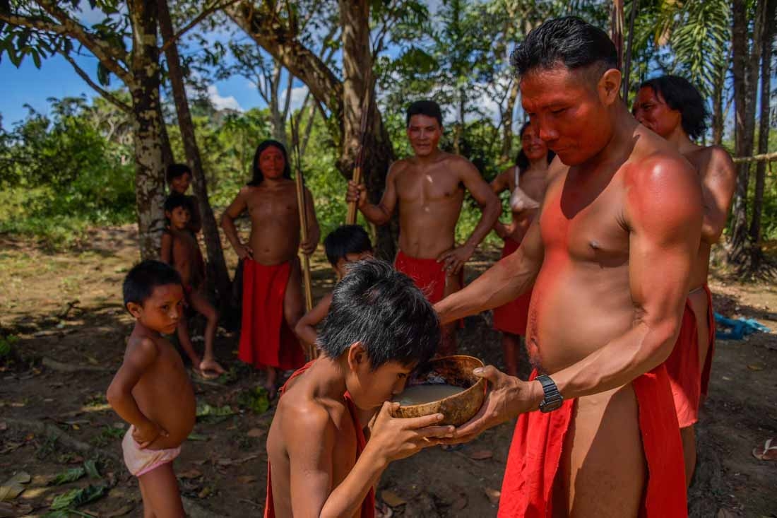 A Waiapi man gives Caxiri, a craft beer made with Manioc, imbibed daily by men, women and children when is not yet sour yet, at the indigenous reserve Waiapi on the Manilha village in Amapa state in Brazil on October 12, 2017.