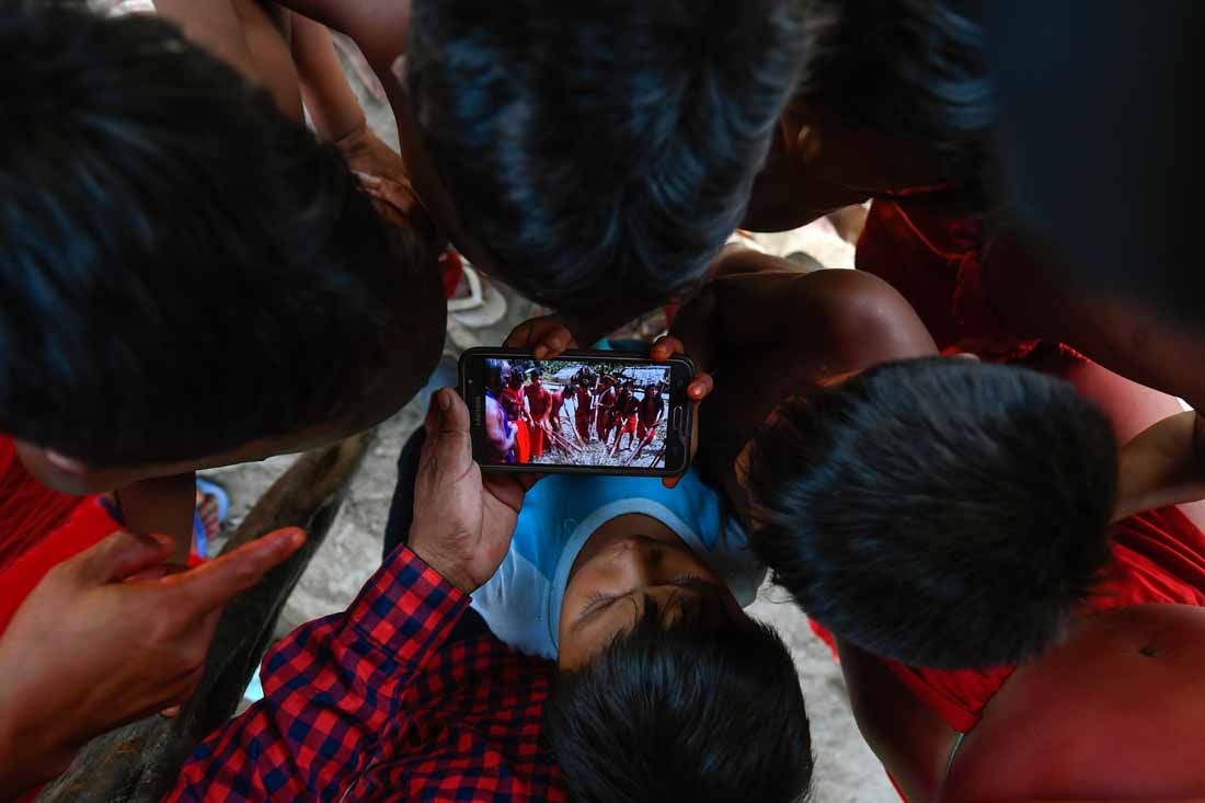 Waiapi children watch a video of a traditional Waiapi dance in a mobile phone at the Manilha village at the indigenous reserve Waiapi in Amapa state in Brazil on October 12, 2017. The Waiapi are one of the most traditional tribes in Brazils Amazon, but