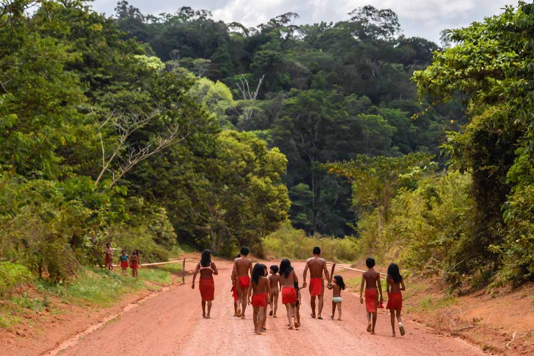 Brazilian Waiapi walk on the road of the Waiapi indigenous reserve, at Pinoty village in Amapa state in Brazil on October 12, 2017. The Waiapi are one of the most traditional tribes in Brazils Amazon, but modern life is getting closer and the forest d