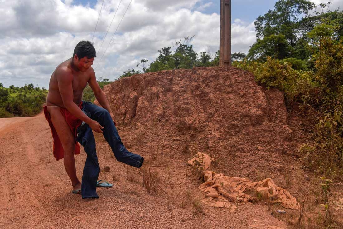 Kamon Waiapi puts on pants right before arriving at the city of Pedra Branca do Amapari in Amapa state in Brazil on October 15, 2017. The Waiapi are one of the most traditional tribes in Brazils Amazon, but modern life is getting closer and the forest