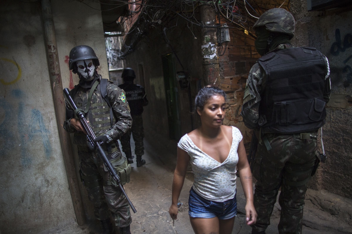 Employing urban combat tactics, Brazilian army military police personnel patrol along an alley in the Rocinha favela in Rio de Janeiro, Brazil on September 25, 2017.