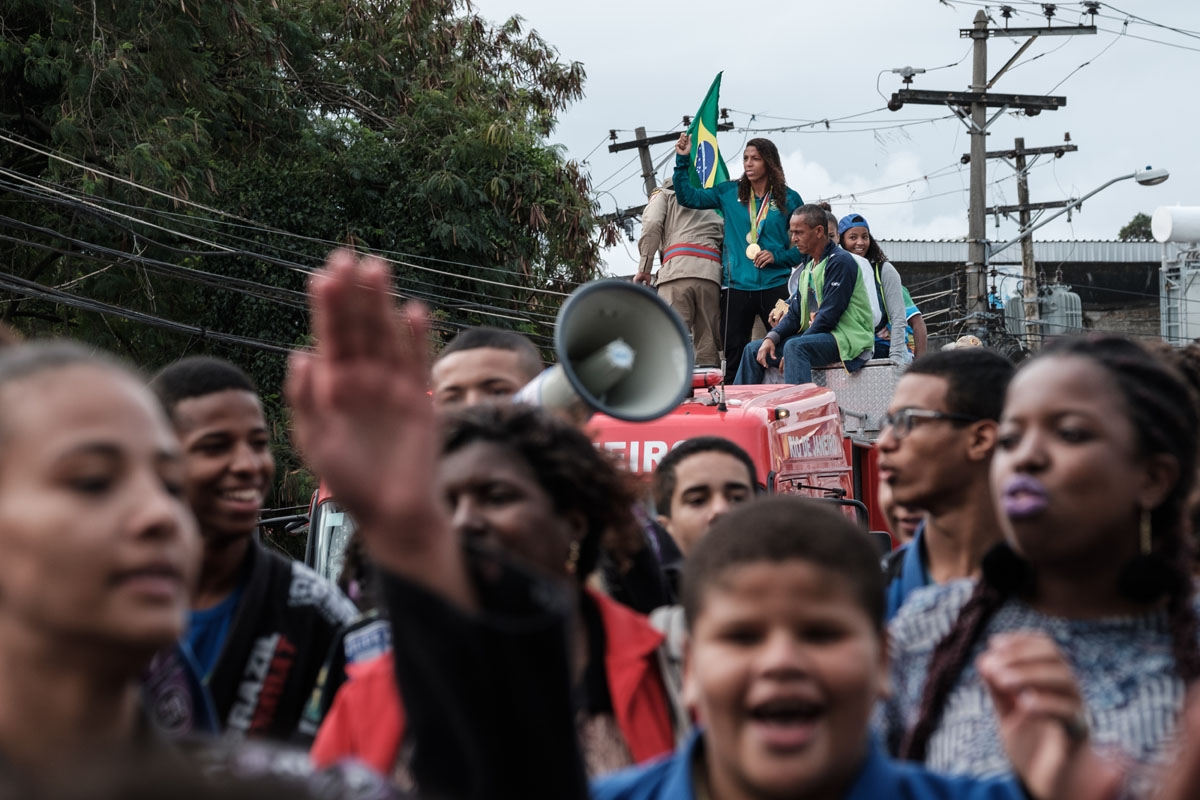 Brazilian judoka Rafaela Silva, wearing the gold medal that she won at the Rio 2016 Olympic Games, waves during a parade in the Cidade de Deus favela where she was born, August 22, 2016.