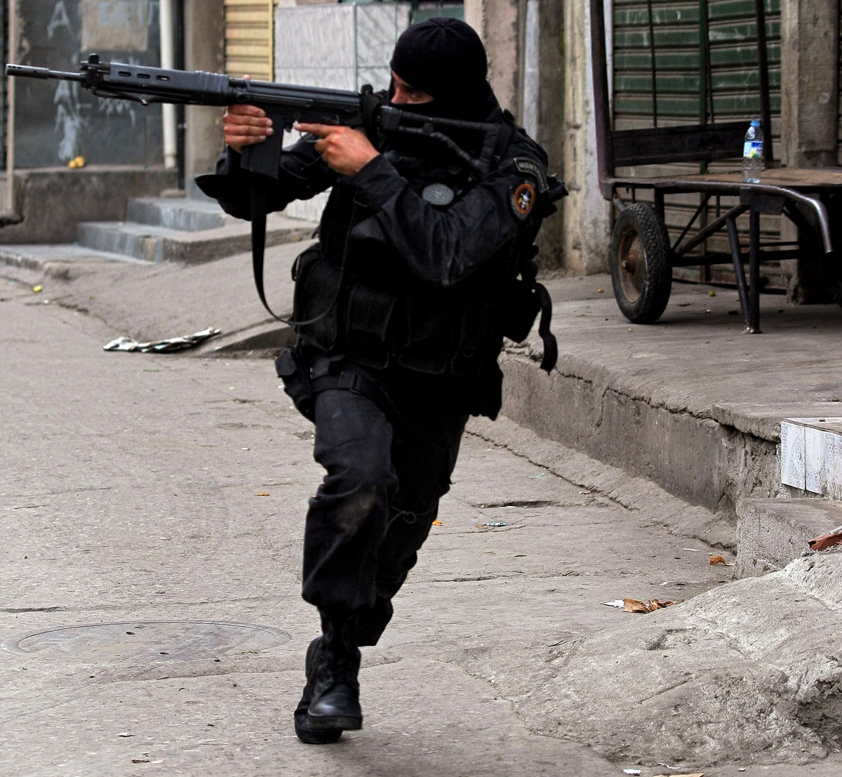 A policeman aims his assault rifle at the entrance of the Alemao favela, north of Rio de Janeiro, June 27, 2007.