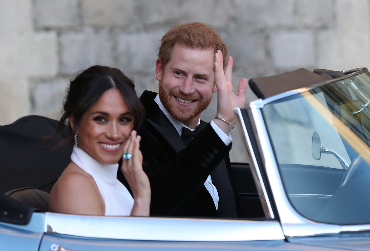 Britain's Prince Harry, Duke of Sussex, (R) and Meghan Markle, Duchess of Sussex, (L) leave Windsor Castle in Windsor on May 19, 2018 in an E-Type Jaguar after their wedding to attend an evening reception at Frogmore House.