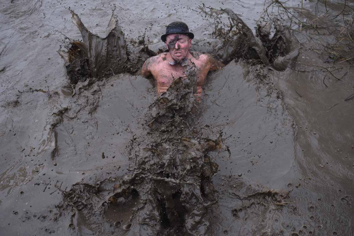 A competitor goes into a muddy pool as he takes part in the 'Tough Guy' adventure race near Wolverhampton, central England, on January 29, 2017. The Tough Guy event, which is being held for the final time in its 30th year, challenges thousands of competi