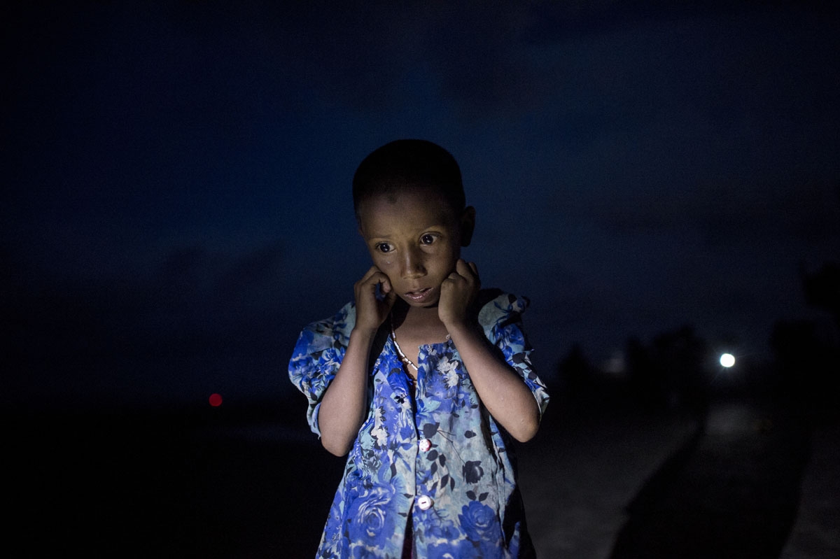 A Rohingya Muslim refugee walks by night after crossing the border from Myanmar, on the Bangladeshi shores of the Naf river in Teknaf on September 29, 2017.