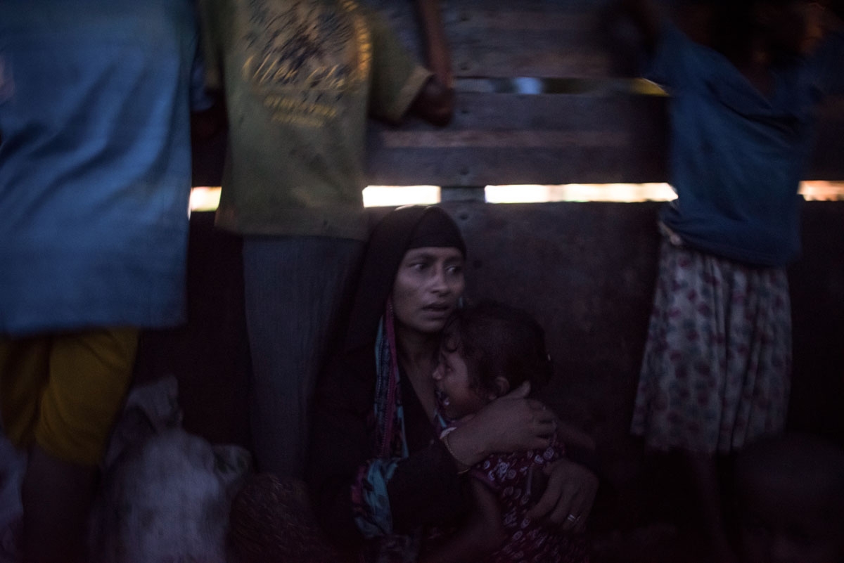 A Rohingya Muslim refugee holds her daughter as they are evacuated in a truck to a refugee camps after crossing the Naf River, in Teknaf, Bangladesh's Ukhia district on October 8, 2017.