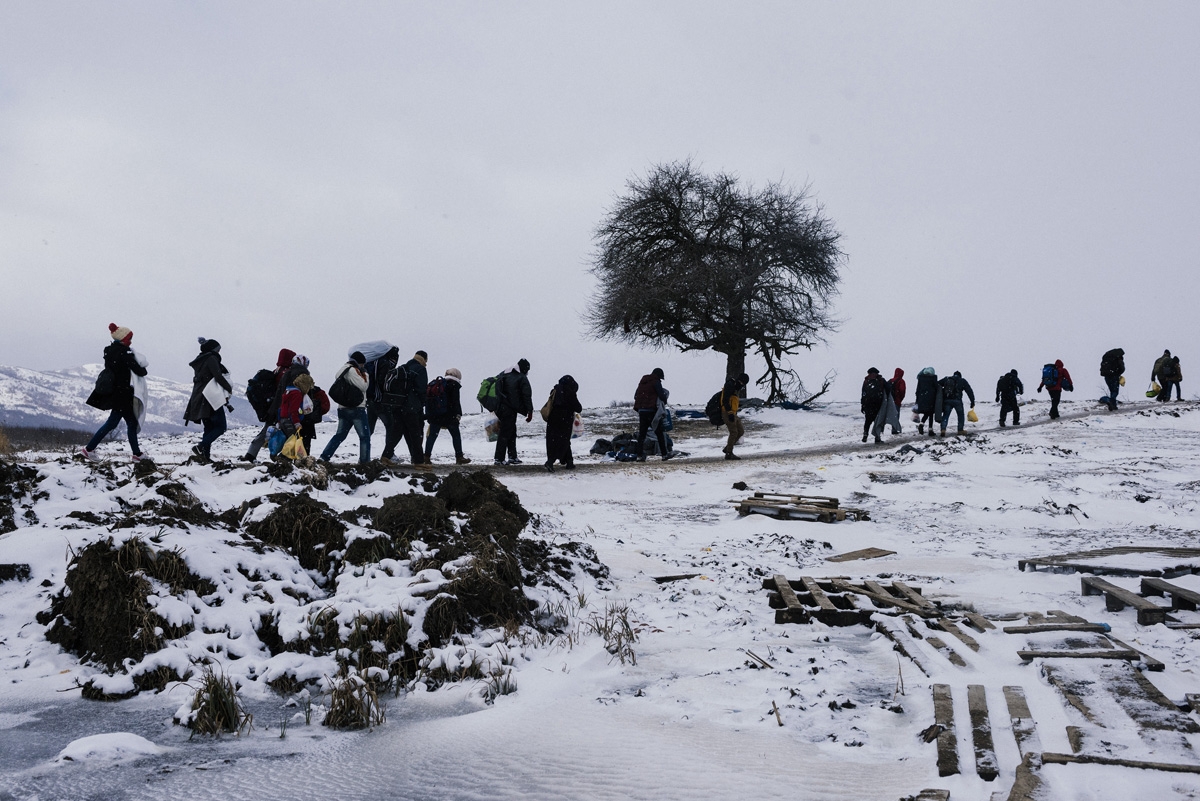 Migrants and refugees walk through snow covered fields, after crossing the Macedonian border into Serbia near the village of Miratovac, on January 18, 2016. More than one million migrants reached Europe in 2015, most of them refugees fleeing war and v