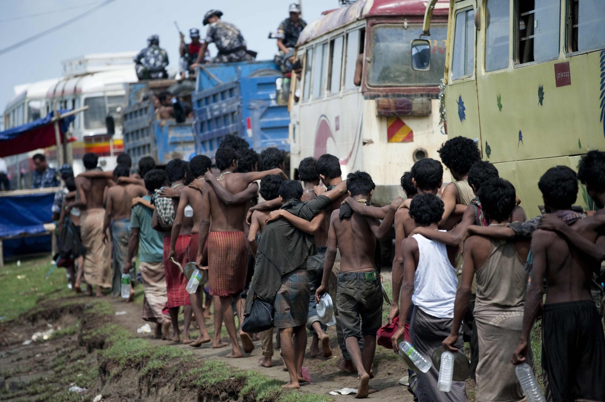 Migrants, who were found at sea on a boat, leave as they are moved from a temporary shelter near the Kanyin Chaung jetty to MeeThike sub-township outside Maungdaw township, northern Rakhine state on June 4, 2015. More than 700 migrants found adrift on a