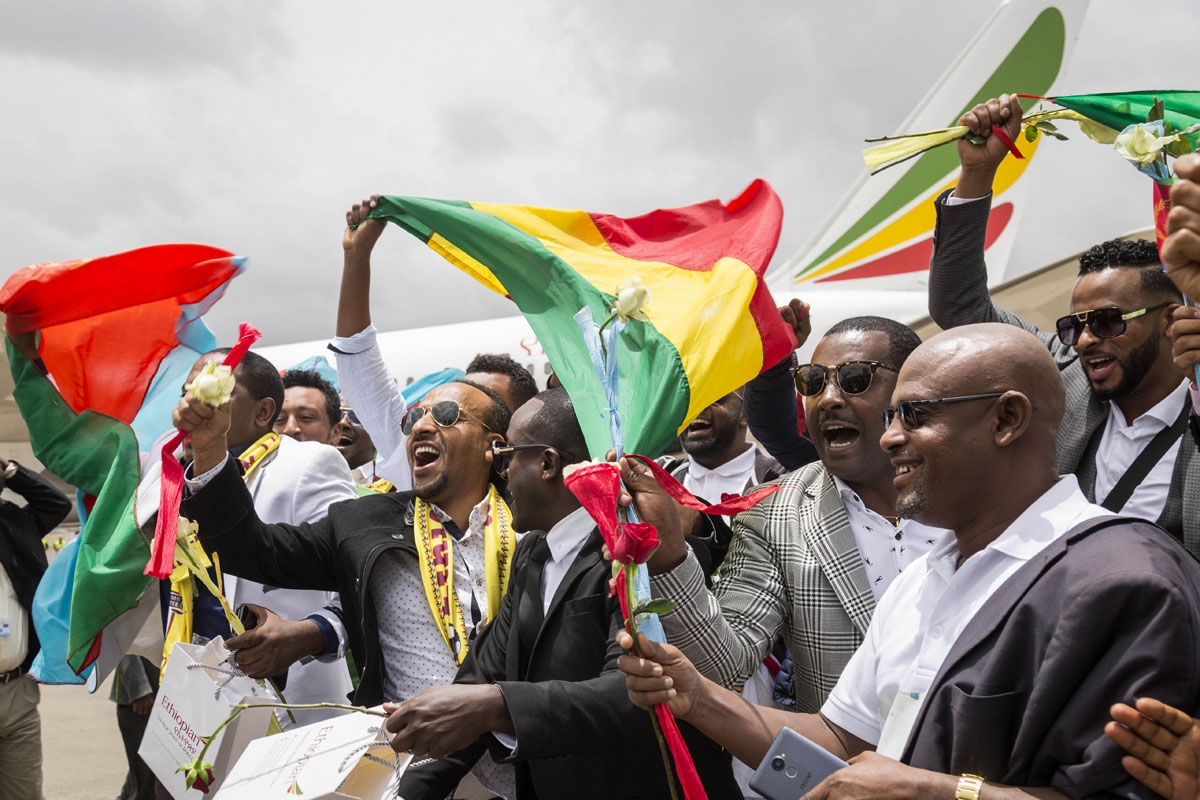 Passengers with Ethiopian and Eritrean flags celebrate on the tarmac after their arrival at Asmara airport on July 18, 2018.