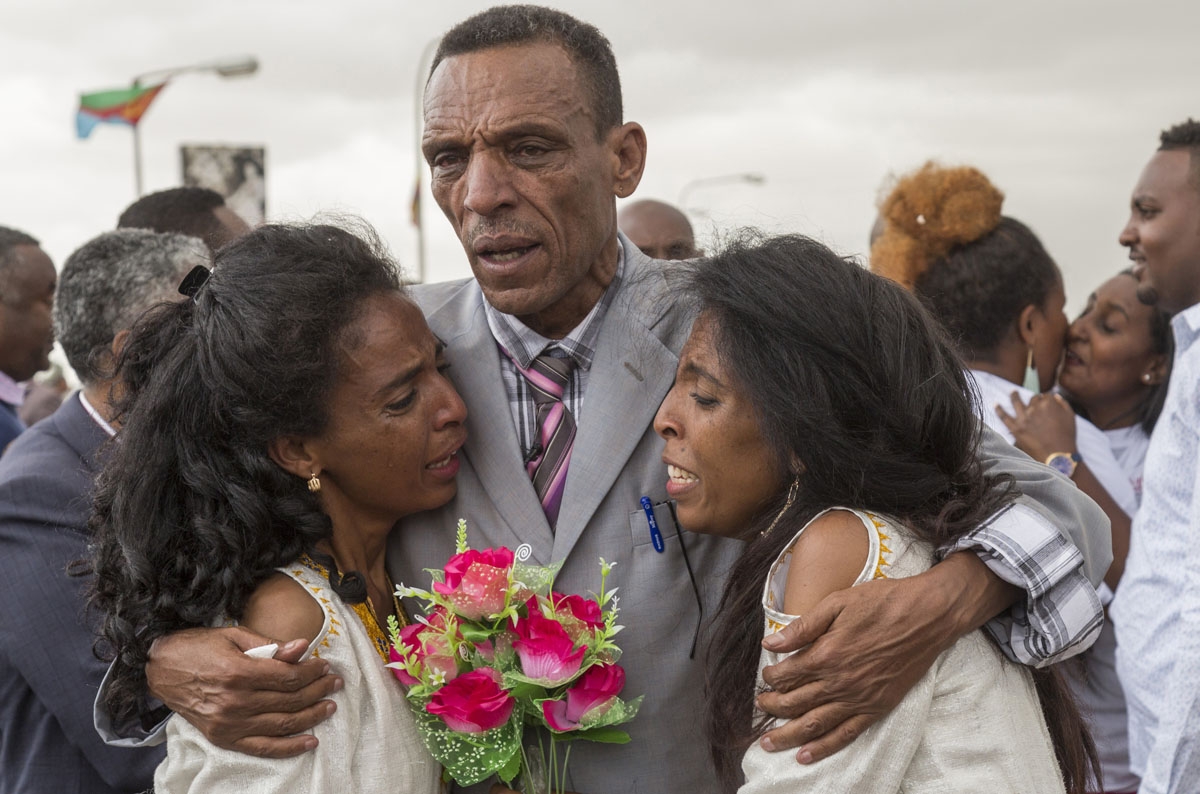 Azmera Addisalem and Danait Addisalem cry and hug their father, an Ethiopian journalist, at Asmara International airport on July 21, 2018, as they are reunited for the first time in 20 years.