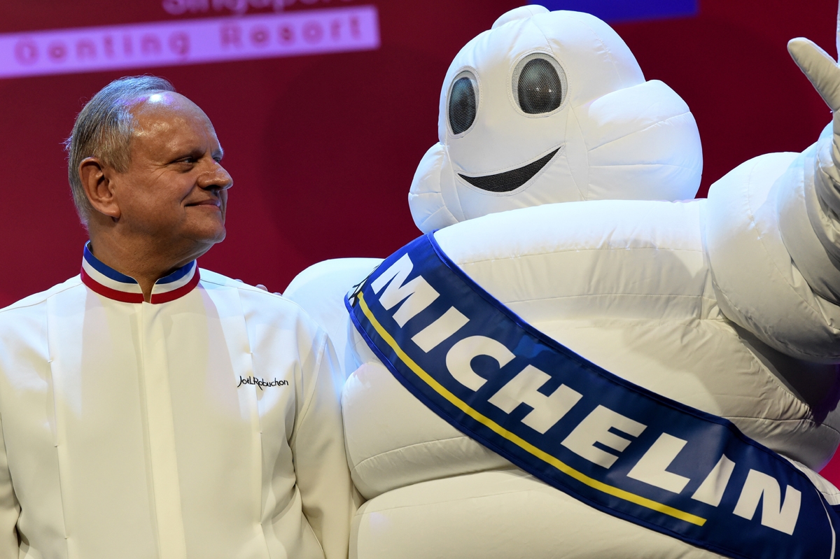 Joel Robuchon poses with the Michelin mascot during the Michelin Guides Award ceremony in Singapore, July, 2016.