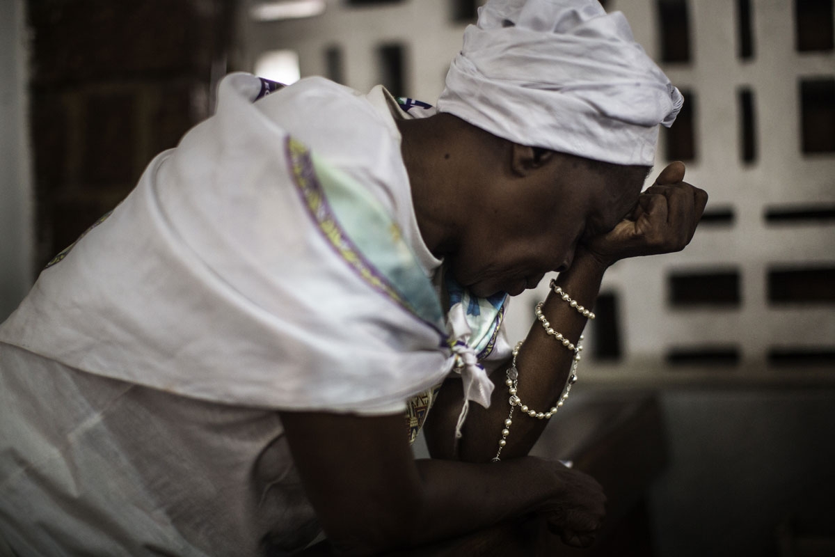 A Catholic woman prays at the St. Michel Church in Libreville on August 28, 2016 during the Sunday's service. 