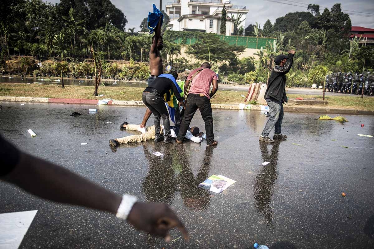 A supporter of Gabonese opposition leader Jean Ping lies on the ground in Libreville on August 31, 2016, during clashes with riot police as part of a protest sparked after Gabon's president Ali Bongo was declared winner of last weekend's contested electio