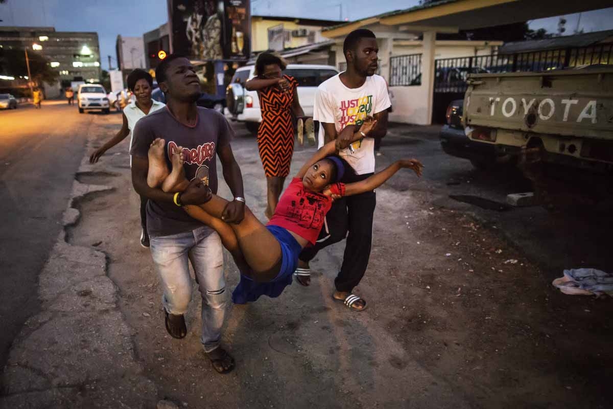 A relative a man detained during clashes is carried to the hospital after she fainted on September 1, 2016 in Libreville.