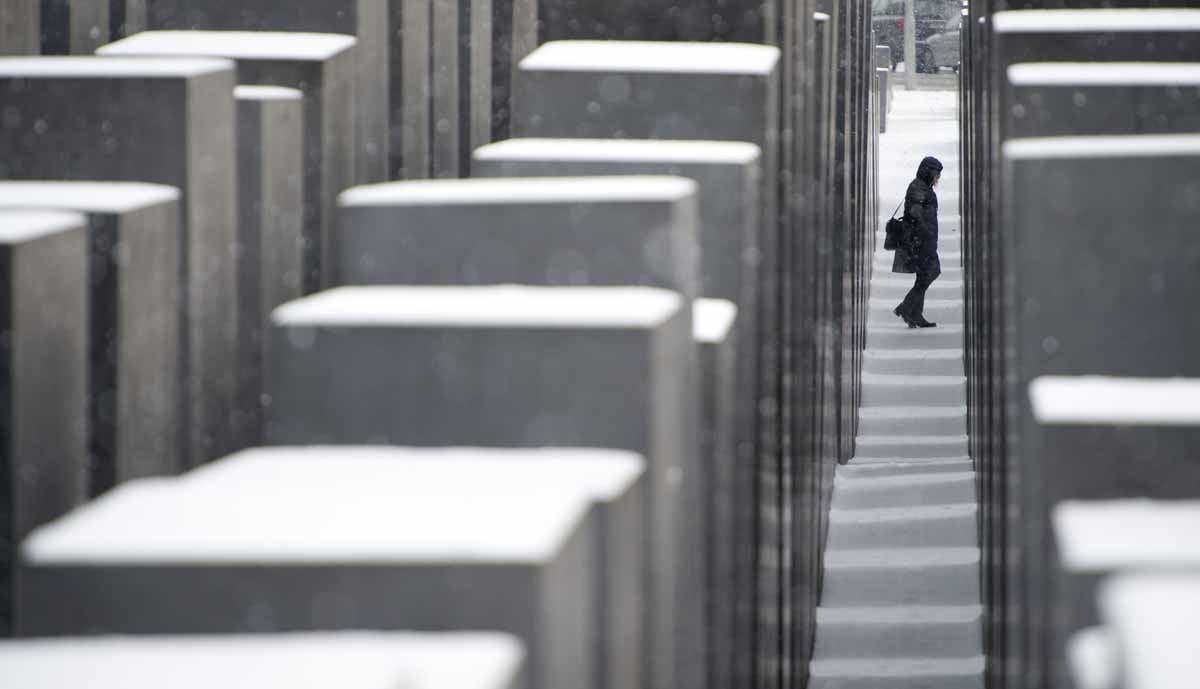 A visitor walks among the snow covered concrete slabs at the Memorial for the murdered Jews in Europe in Berlin on January 14, 2013. Temperature dropped over night and snow followed at daybreak in the German capital.