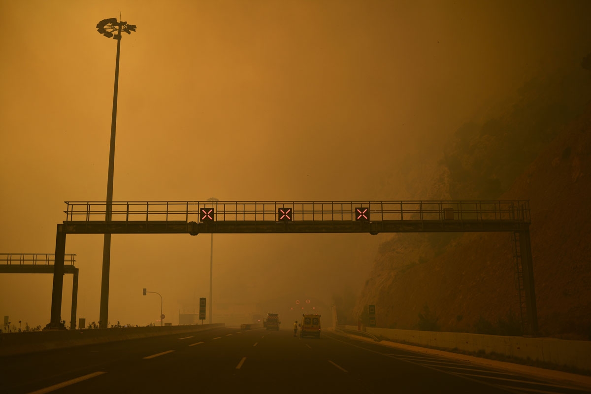 This photo taken on July 23, 2018 shows a road block as a wildfire burns in Kineta, near Athens.