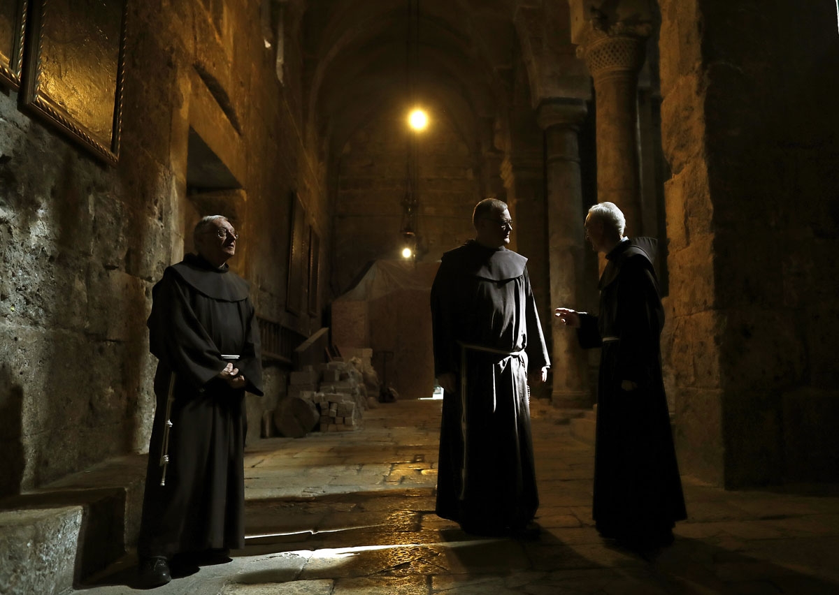 Franciscan friars discuss in a corridor in the Church of the Holy Sepulchre in the Old City of Jerusalem, on February 21, 2018. Dispatched to the city 800 years ago by the Catholic order's founder, Saint Francis of Assisi, the Franciscans have for centuri