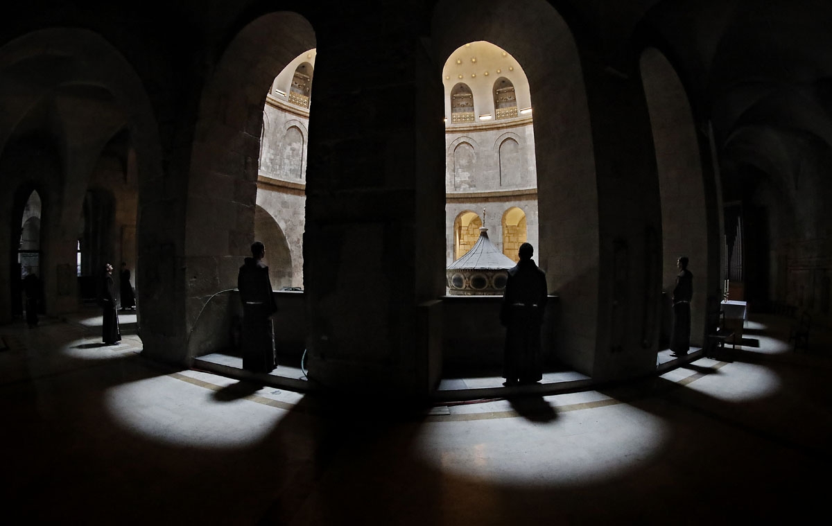Franciscan friars observe the tomb of Jesus from the gallery at the Church of the Holy Sepulchre in the Old City of Jerusalem, on February 17, 2018. Dispatched to the city 800 years ago by the Catholic order's founder, Saint Francis of Assisi, the Franci