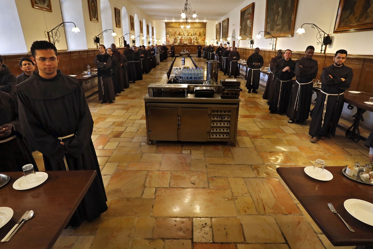 Franciscan friars pray before having dinner at the refectory inside the Saint Saviour Convent, the Franciscan headquarters in the Old City of Jerusalem, on March 15, 2018.