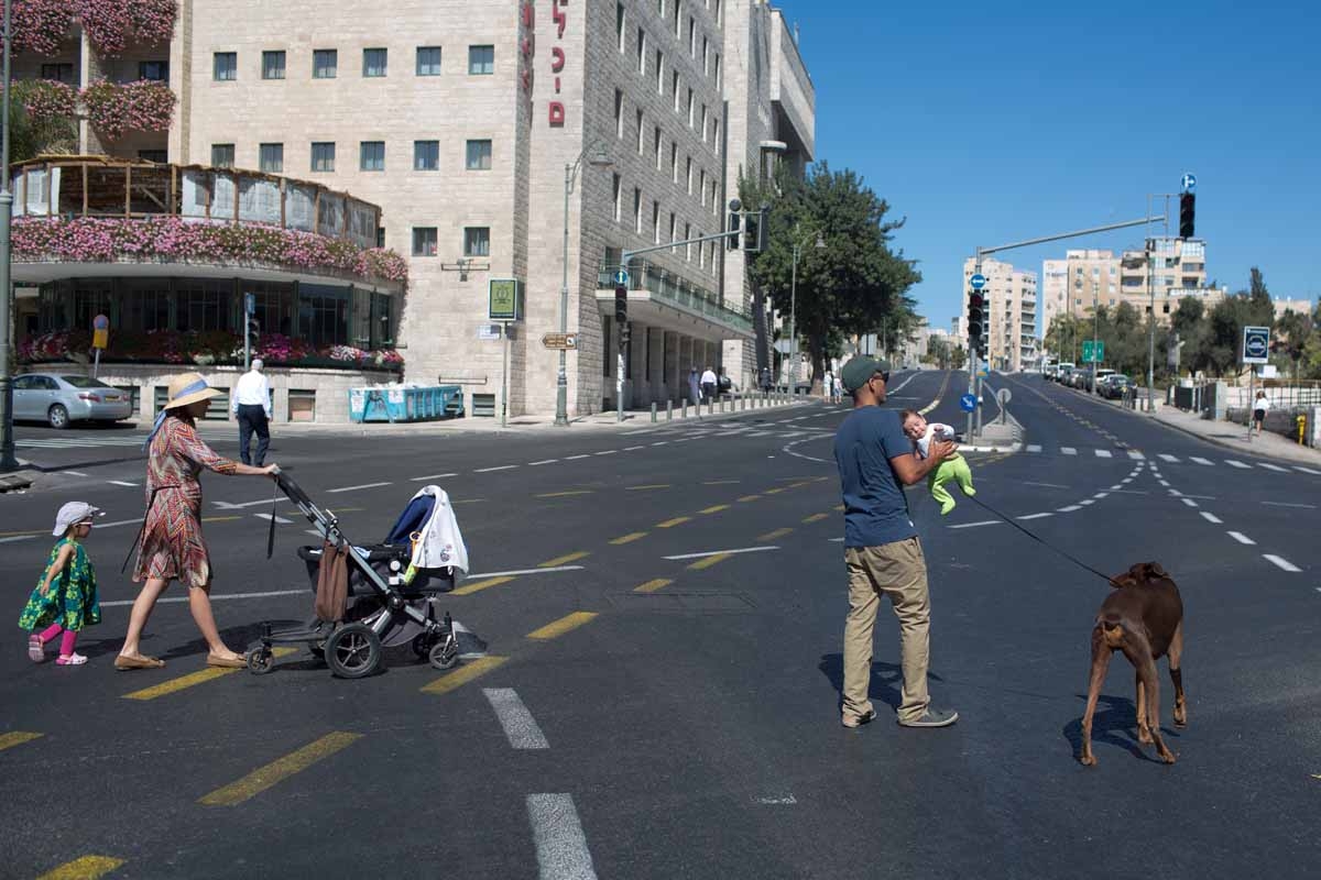 An Israeli family walks on a car-free road in Jerusalem during the solemn Jewish fast of Yom Kippur on October 4, 2014. Yom Kippur, which means the Day of Atonement, is marked with a 25-hour fast beginning before sunset the previous day.
