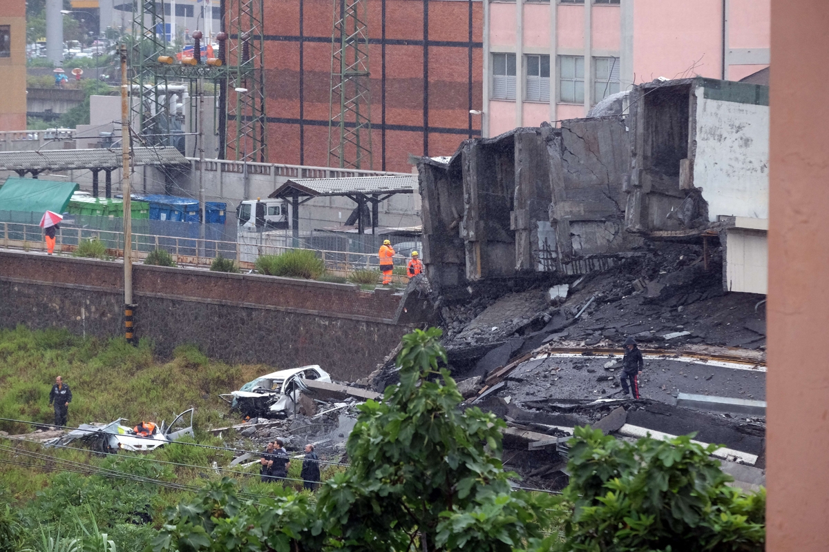 Rescuers are at work amid the rubble of a section of a giant motorway bridge that collapsed earlier, on August 14, 2018 in Genoa.