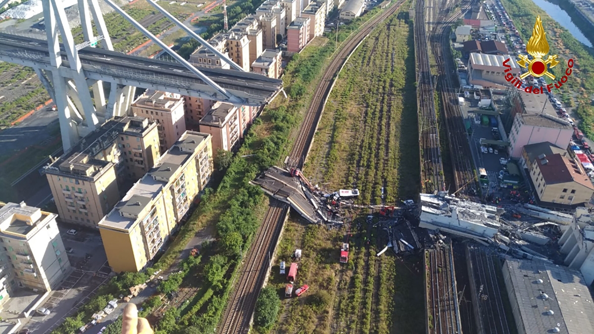 This handout picture taken and released by the Vigili del Fuoco, the Italian fire and rescue service, on August 15, 2018, shows rescuers at work amid rubble and wreckage after the collapse of a section of the Morandi motorway bridge in Genoa.