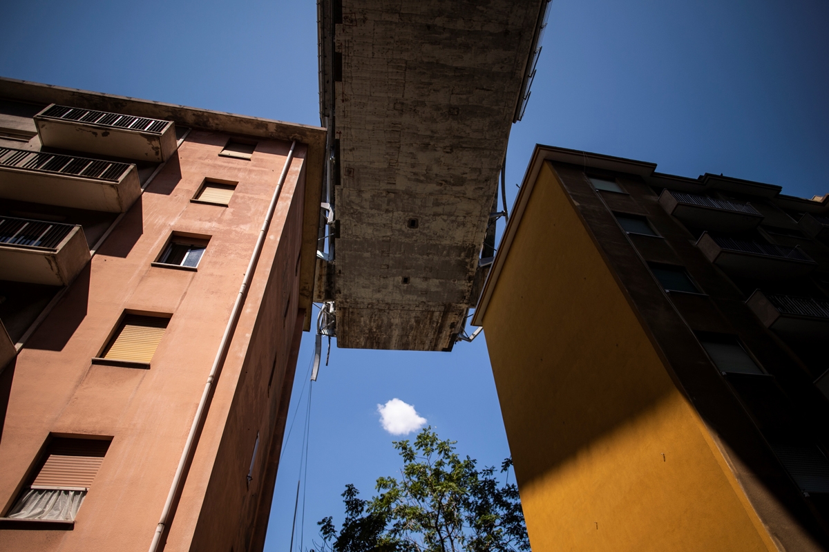 Appartment buildings are seen under the Morandi motorway bridge, two days after a section collapsed in Genoa on August 16, 2018.