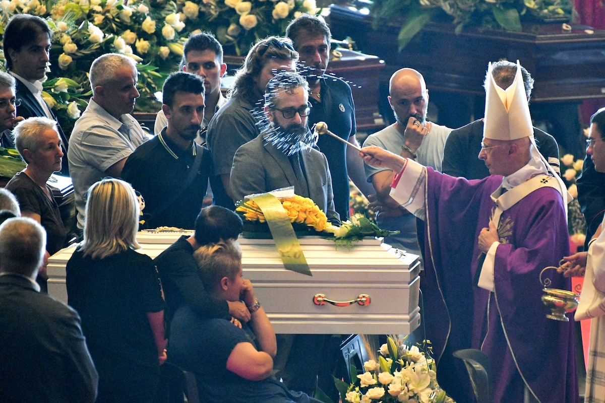 Archbishop of Genoa Cardinal Angelo Bagnasco (R) blesses the coffins during the state funeral of the victims of the Morandi Bridge collapse, in Genoa on August 18, 2018.