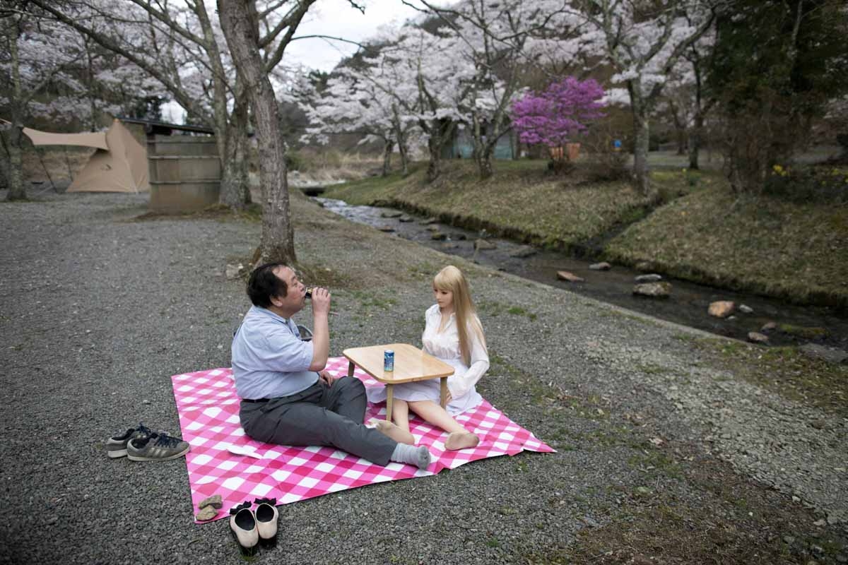 Senji Nakajima con su muñeca Saori bajo los cerezos en flor, en Yamanashi, Japón, el 13 de junio de 2017