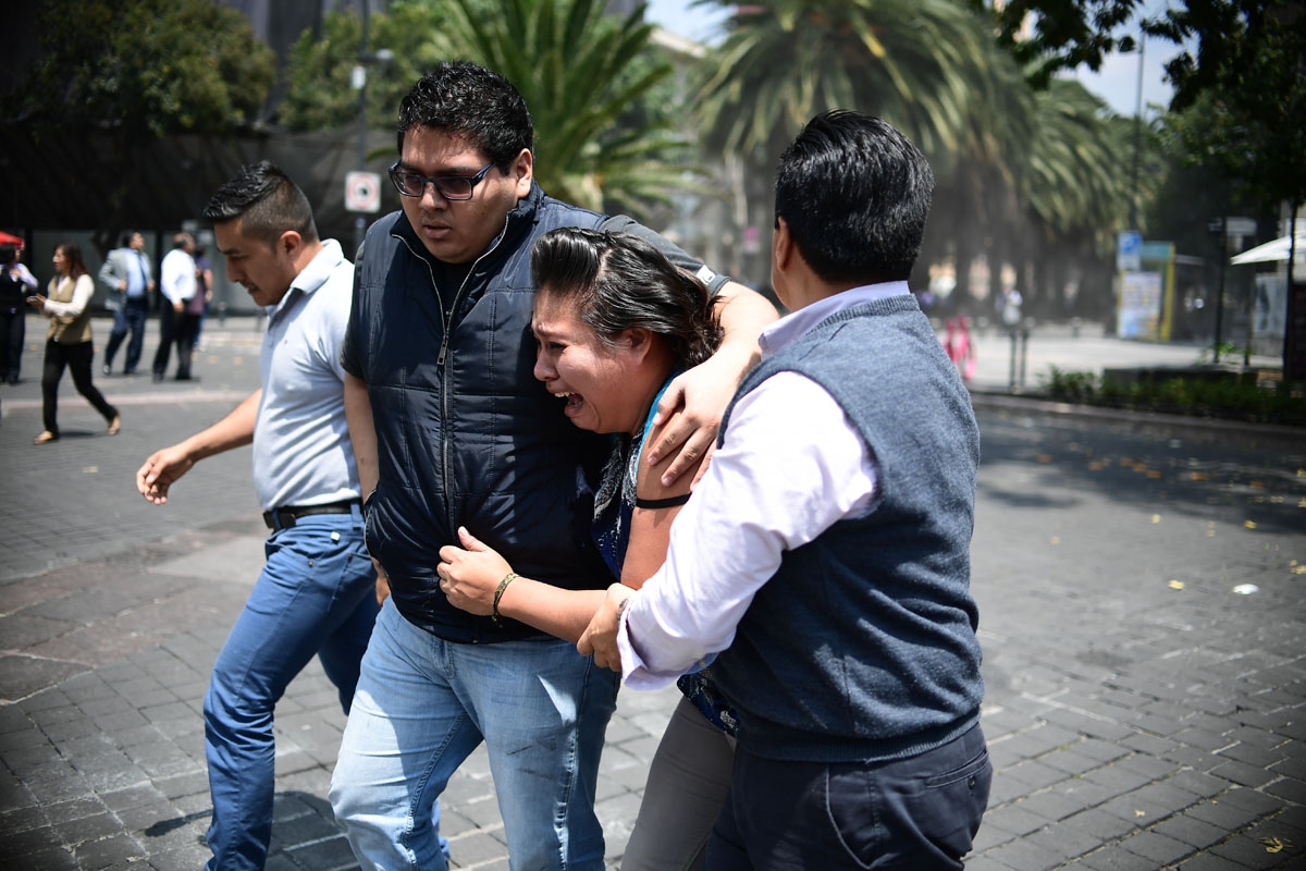 People react as a real quake rattles Mexico City on September 19, 2017 moments after an earthquake drill was held in the capital.