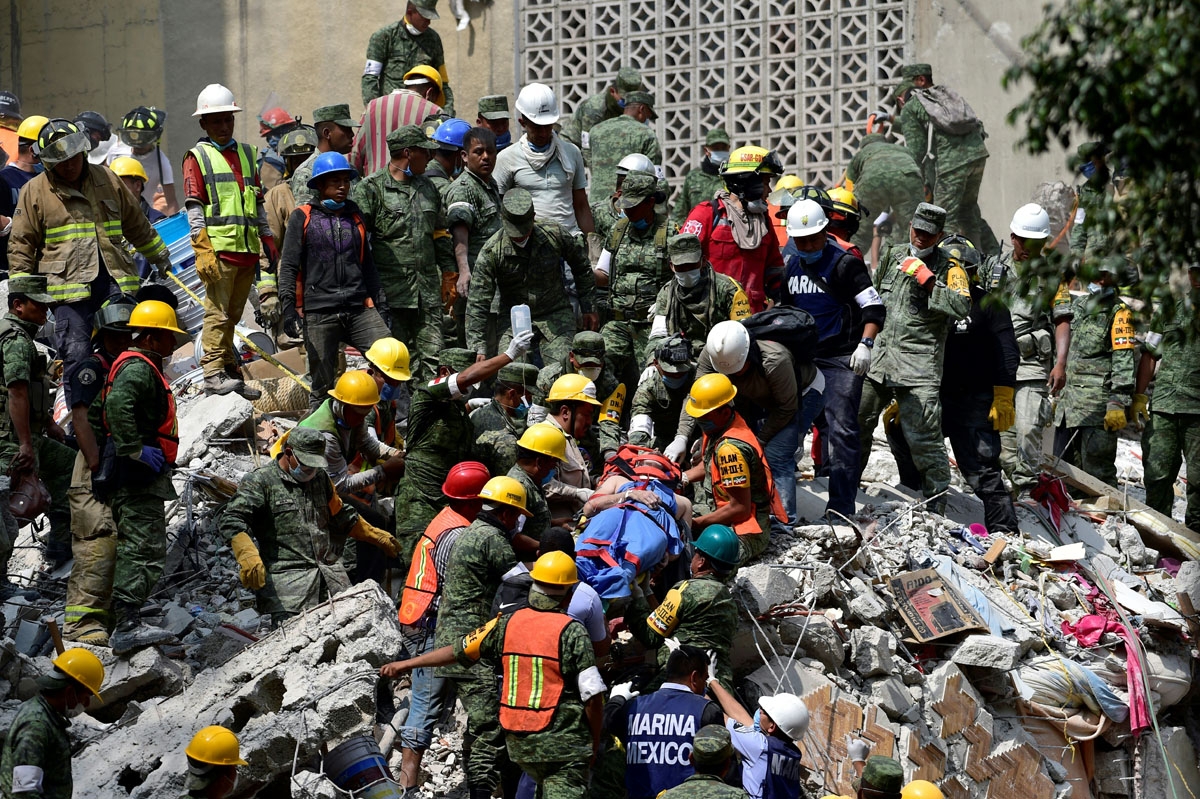 A man is pulled out of the rubble alive in Mexico City on September 20, 2017 as the search for survivors continues a day after a strong quake hit central Mexico.