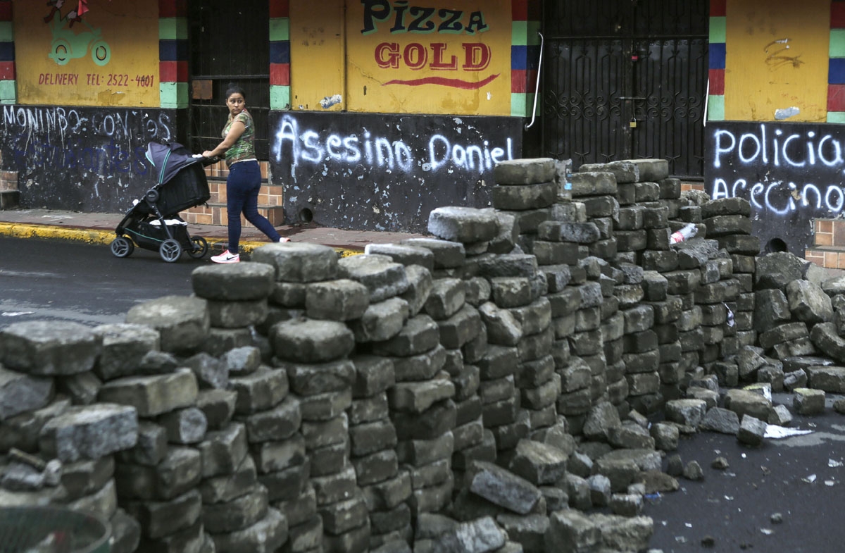 woman looks back after passing by a barricade in the neighbourhood of Monimbo, in Masaya, a city some 35 km from Managua, on May 21, 2018.