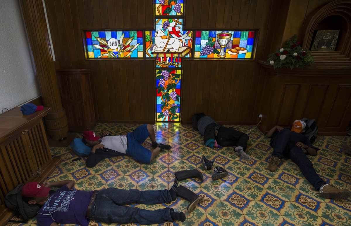 Peasants who spent the night at the Metropolitan Cathedral in Managua, where they took refuge during deadly clashes after a march marking Nicaragua's National Motherâs Day, rest inside the church on May 31, 2018.