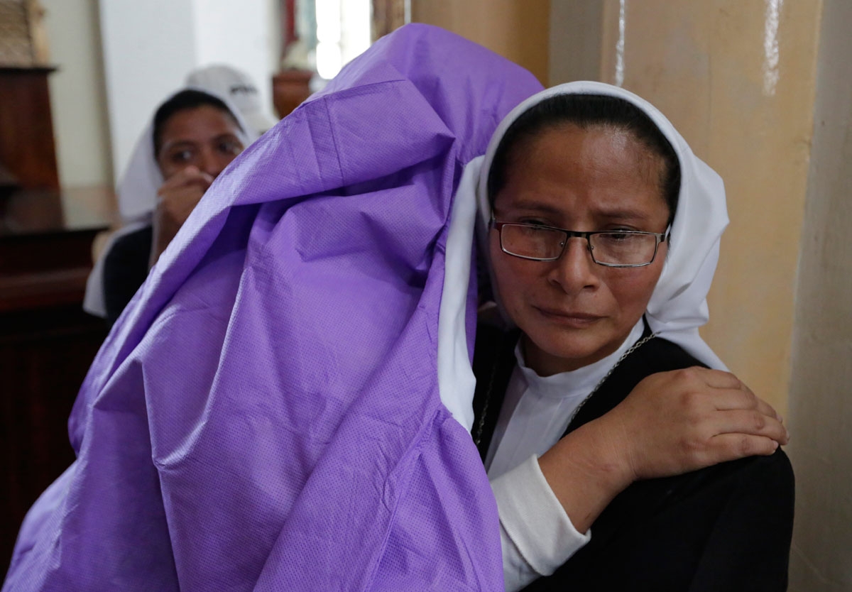 A woman afraid of pro-government Sandinista youths embraces a nun as she takes shelter at the San Sebastian Basilica in Diriamba, Nicaragua, on July 9, 2018. Hundreds of under-pressure Nicaraguan President Daniel Ortega supporters broke into the basilica