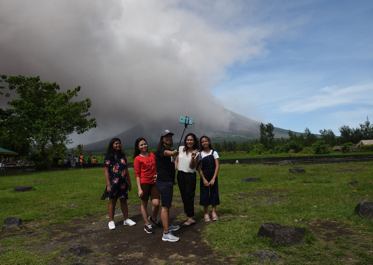 Taking selfies, with an erupting Mayon in the background on January 30, 2018.