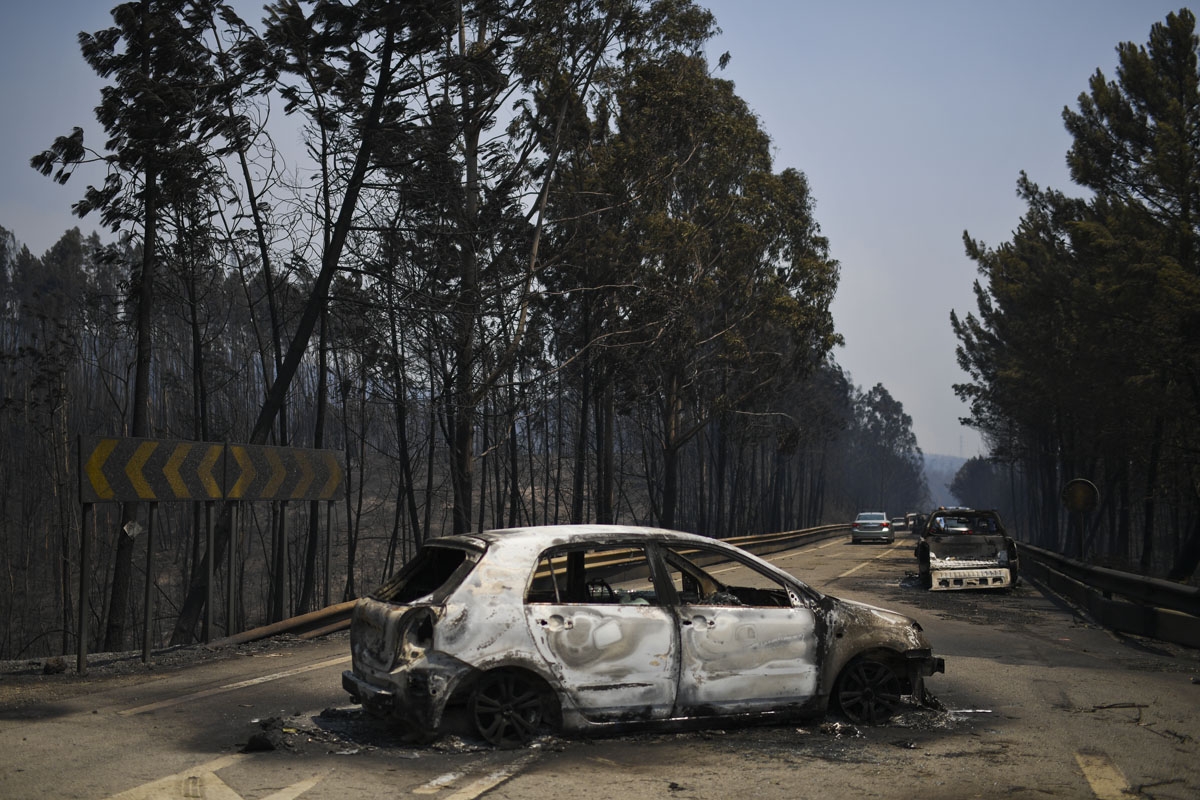 A picture taken on June 18, 2017 shows burnt cars on a road after a wildfire in Figueiro dos Vinhos.