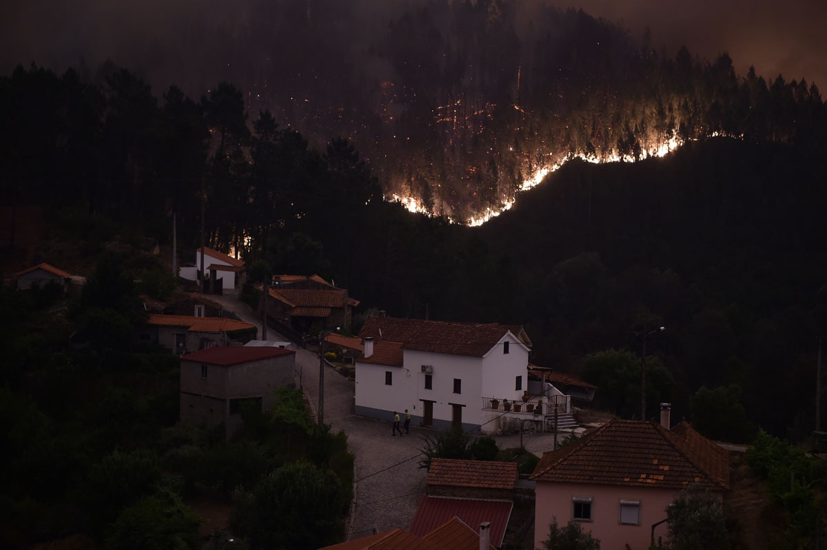 A picture taken on June 18, 2017 shows flames and smoke during a wildfire near the village of Mega Fundeira.