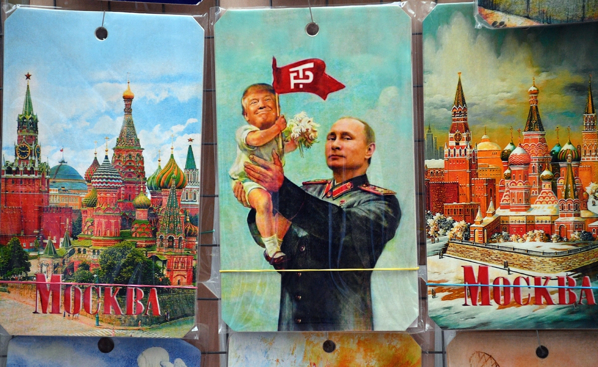 A picture taken on July 5, 2017 shows a souvenir kiosk offering a drawing depicting Russian President Vladimir Putin holding a baby with the face of US President Donald Trump