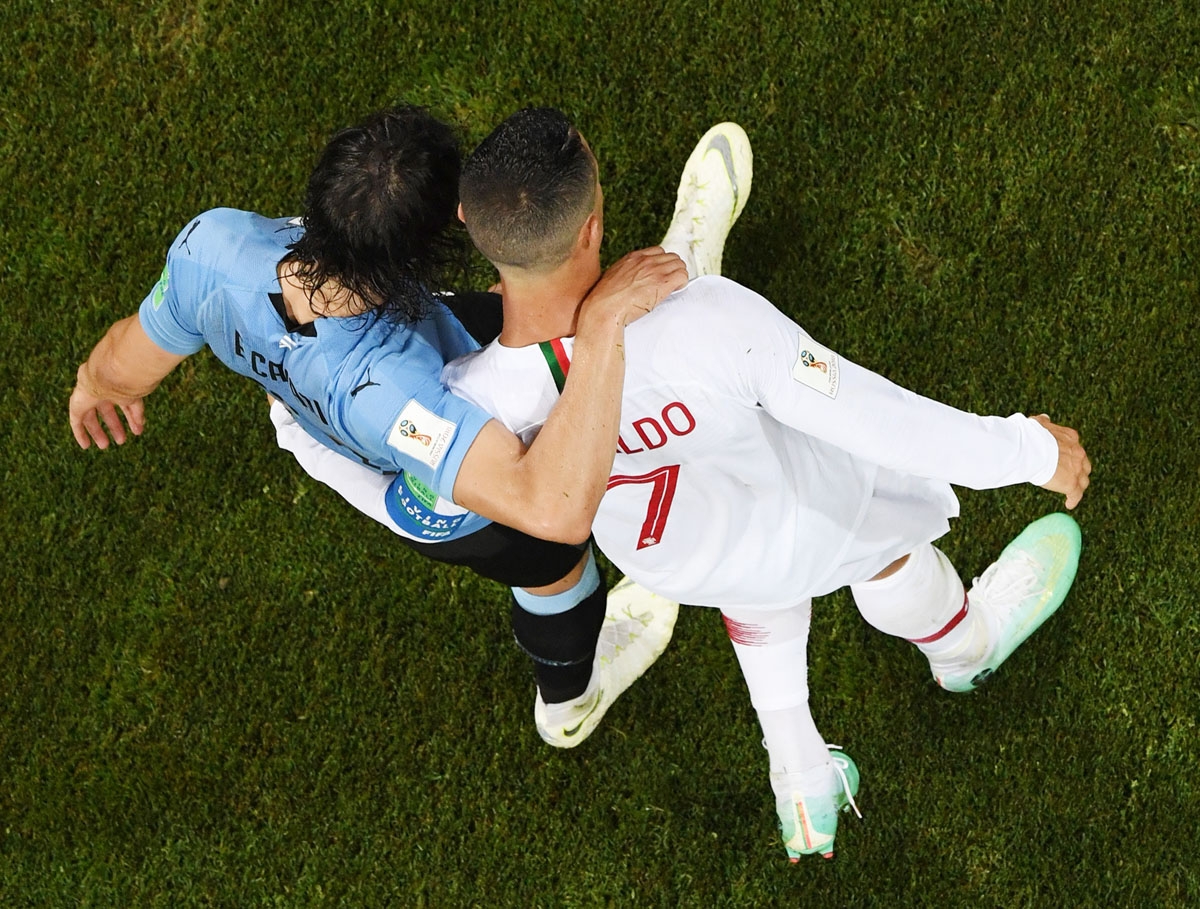 Portugal's forward Cristiano Ronaldo (R) hugs Uruguay's forward Edinson Cavani during the Russia 2018 World Cup round of 16 football match between Uruguay and Portugal at the Fisht Stadium in Sochi on June 30, 2018. /