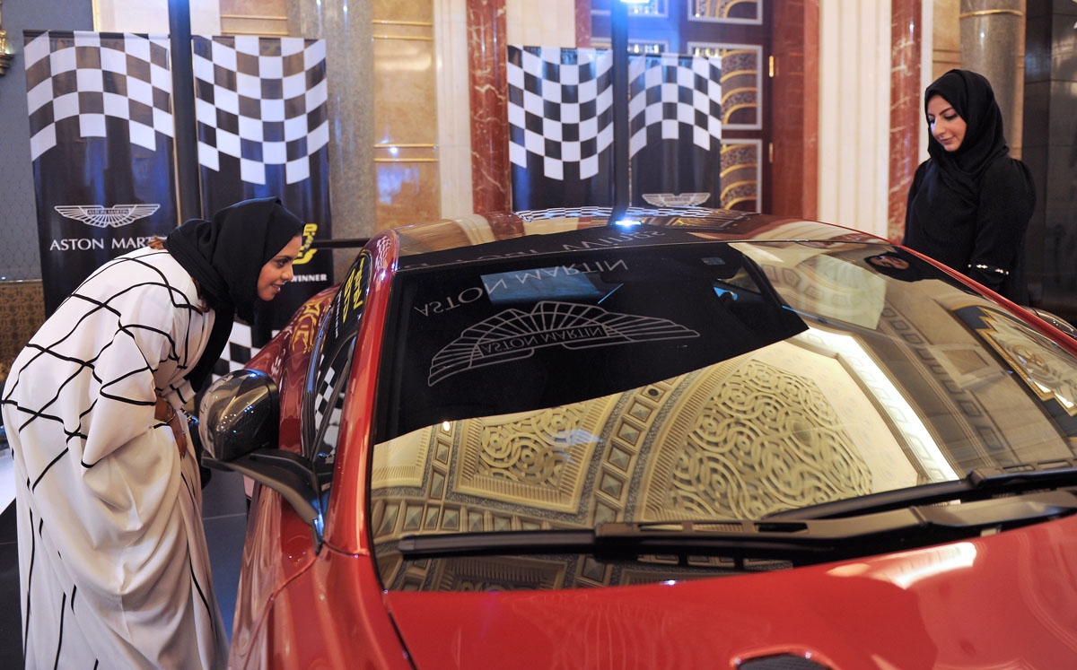 Saudi women check a car at an automobile stand in the Saudi Red Sea resort of Jeddah on October 5, 2017.