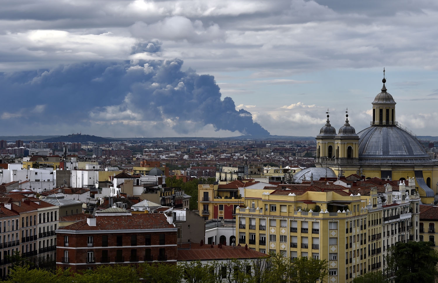 Picture taken from the Almudena cathedral in Madrid shows a huge smoke column caused by a fire in an uncontrolled dump near the town of Sesena, on May 13, 2016 Picture taken from the Almudena cathedral in Madrid shows a huge smoke column caused by a fire in an uncontrolled dump near the town of Sesena, on May 13, 2016