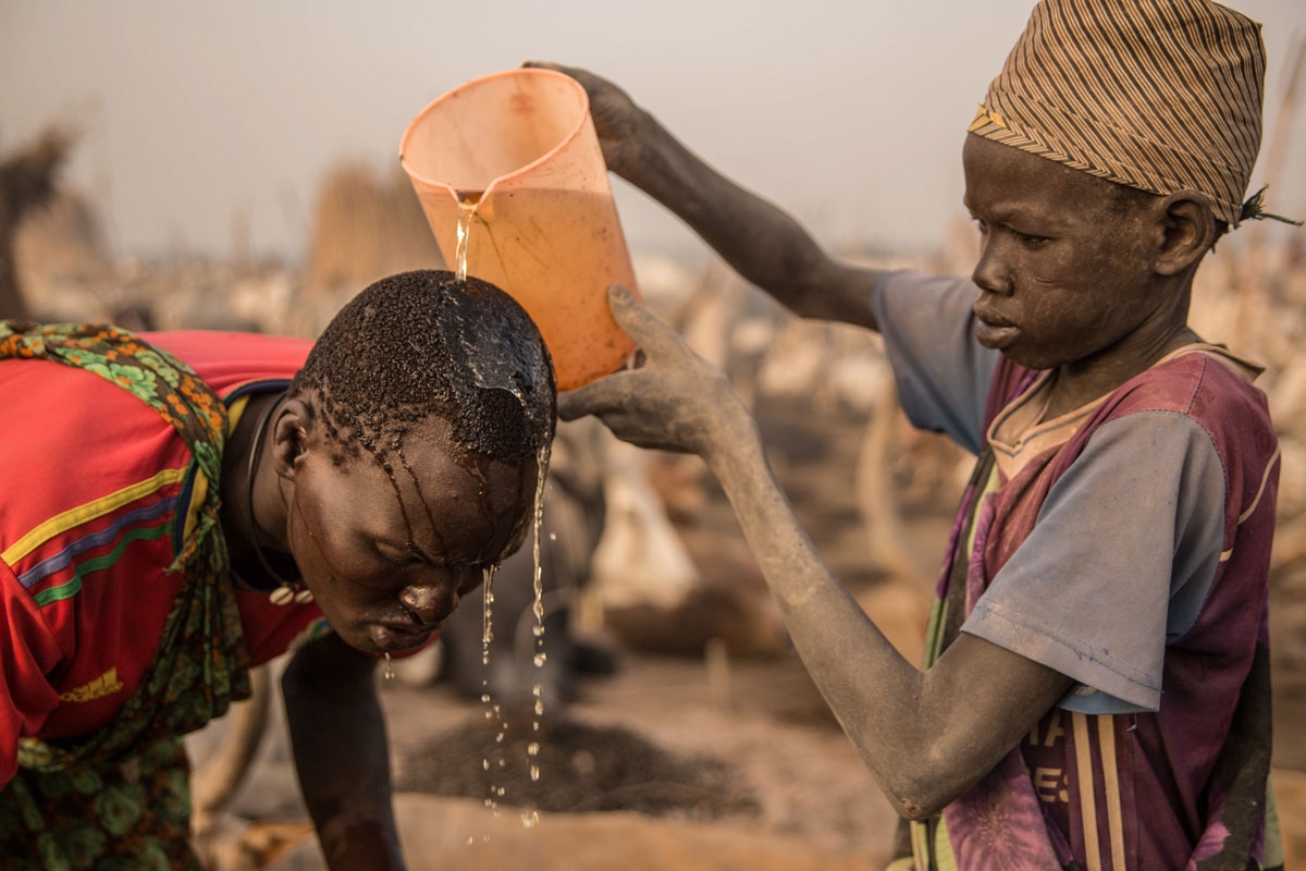 Sudanese boys from Dinka tribe use cow's urine to wash hair at their cattle camp in Mingkaman, Lakes State, South Sudan, on March 3, 2018. During South Sudanâs dry season between December and May, pastoralists from the highlands move to the lowlands and
