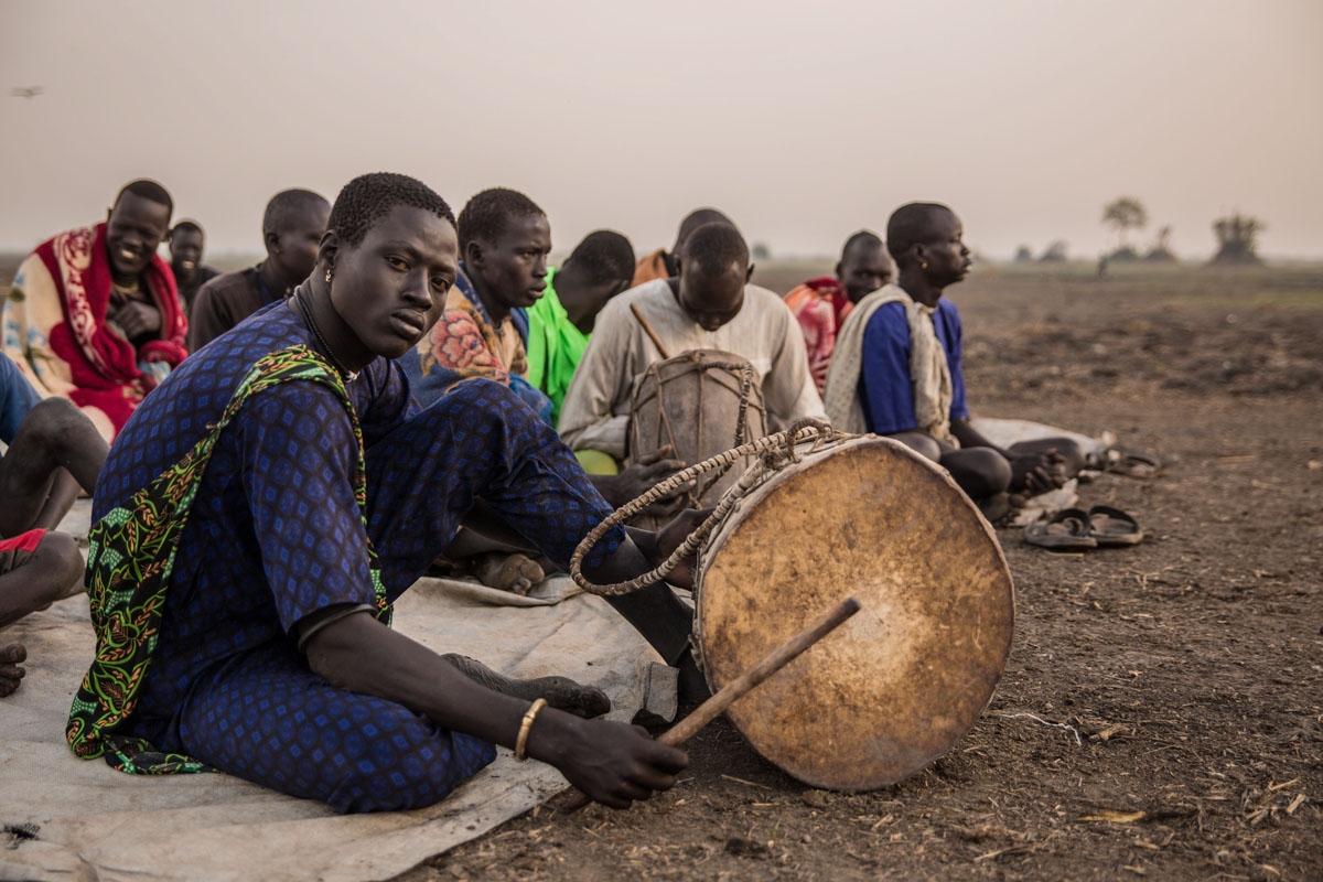 Sudanese cattle herders from Dinka tribe gather their church's prayer in the early morning at their cattle camp in Mingkaman, Lakes State, South Sudan.