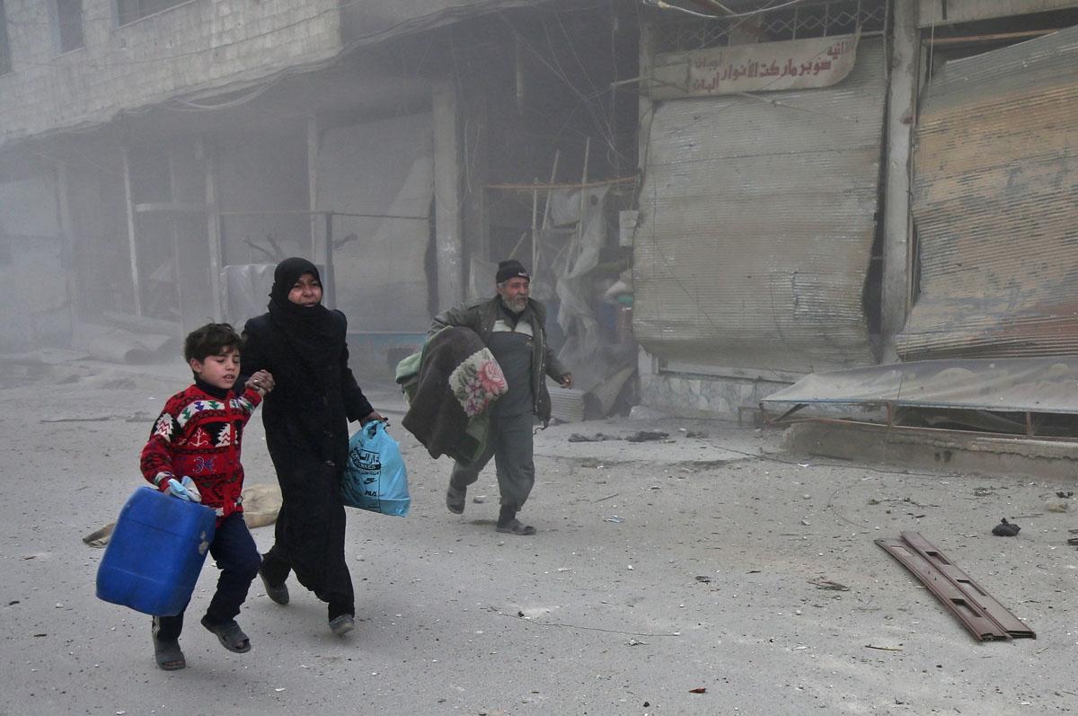 Syrians run for cover in Hammuriyeh following government shelling, March 6, 2018.
