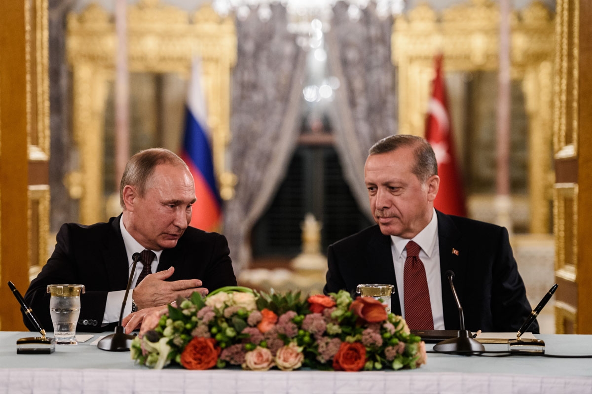 Russian President Vladimir Putin (L) speaks to Turkish President Recep Tayyip Erdogan (R) as they attend a press conference on October 10, 2016 in Istanbul