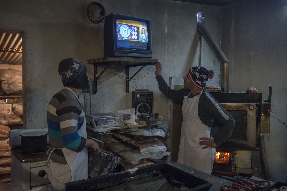 Inmates watch a TV horoscope report as they work in confectionery at the Punta de Rieles prison in Montevideo on June 15, 2016
